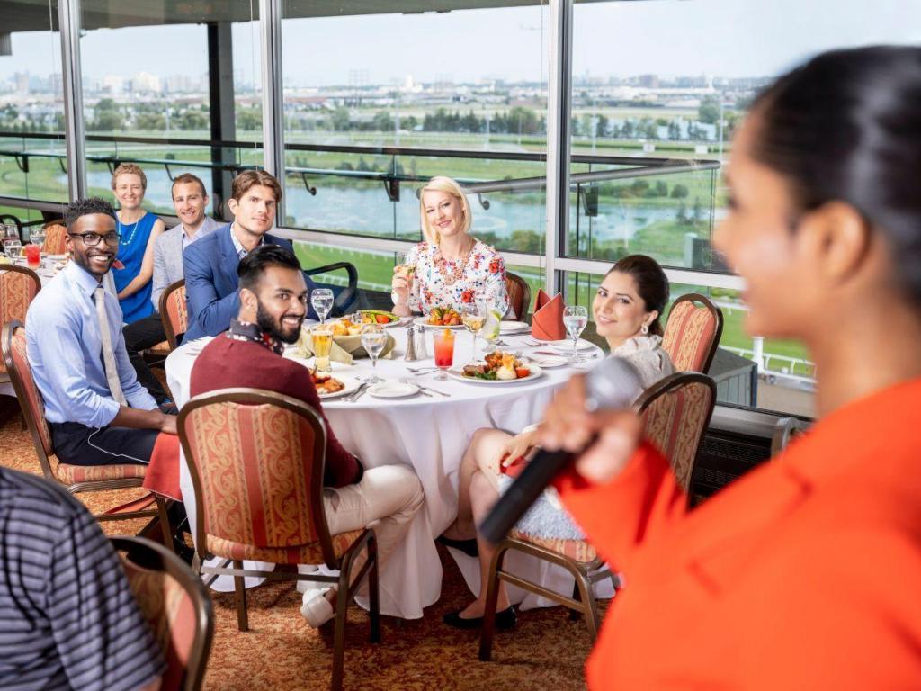 Guests at an office holiday party listen to a speaker