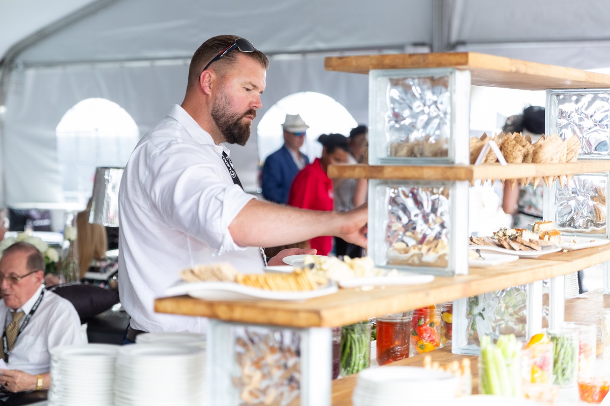 A guest chooses from an array of food at an event at Woodbine Racetrack.